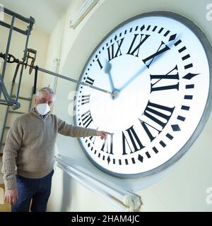 Madrid, Spanien. 13th Dez 2021. Der Uhrmacher der Puerta del Sol, Jesus Lopez-Terradas, posiert mit einer Uhr, die bereit ist, am 31. Dezember in der Puerta del Sol.Madrid Glockenspiele zu geben.die letzten Vorbereitungen, um in 18 Tagen das mythische Glockenspiel des Endes des Jahres zu feiern. Die Uhr, die 1866 in London hergestellt wurde, zählt die 12 Sekunden vor Mitternacht am 31. Dezember, um das neue Jahr 2022 einzuläuten. Kredit: SOPA Images Limited/Alamy Live Nachrichten Stockfoto