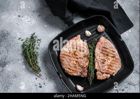 Gegrilltes Schweinefleisch Tender Steaks aus Filetfleisch auf der Grillpfanne. Grauer Hintergrund. Draufsicht Stockfoto