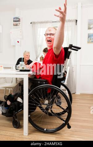 Lächelnder junger Mann im Rollstuhl Stockfoto