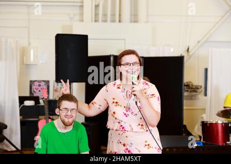 Frau hält Mikrofon und gibt Mann Hase Ohren Stockfoto