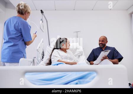 Weibliche Patientin, die mit Krankenschwestern spricht Stockfoto