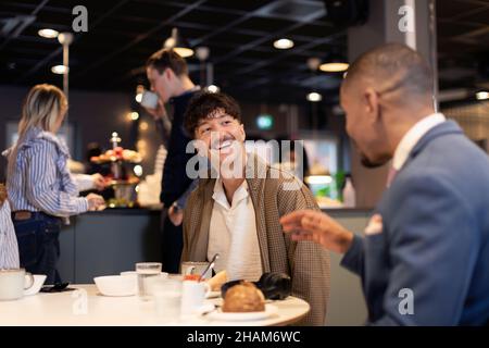 Kollegen sprechen während des Mittagessens Stockfoto