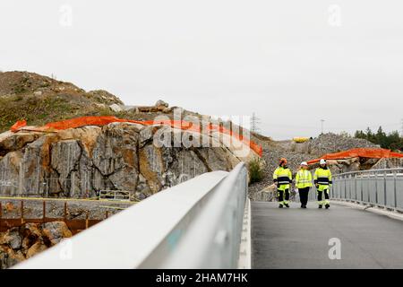 Ingenieure in reflektierender Kleidung gehen auf der Brücke Stockfoto