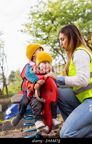 Vorschullehrer mit Schülern auf dem Spielplatz Stockfoto