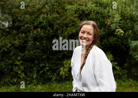 Porträt der lächelnde junge Frau im weißen Bademantel Stockfoto