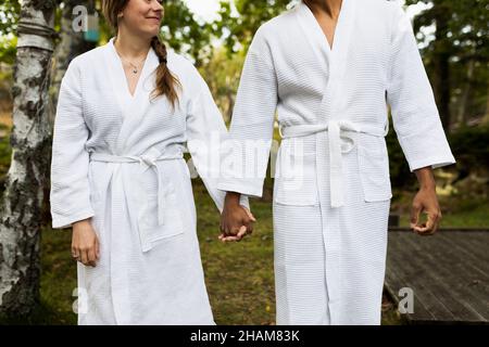 Paar im Bademantel Hand in Hand Stockfoto