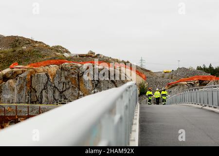 Ingenieure in reflektierender Kleidung gehen auf der Brücke Stockfoto