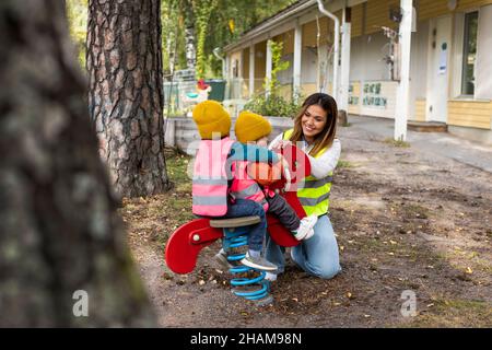 Vorschullehrer mit Schülern auf dem Spielplatz Stockfoto