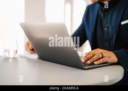 Die Hände des Mannes auf Laptop-Tastatur Stockfoto