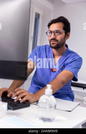Arzt im Büro mit Computer Stockfoto