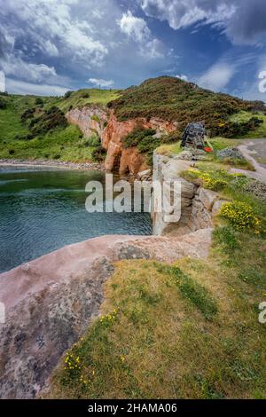 Cove Harbor an einem sonnigen Tag. Eine kleine einsame Hafenbucht an der Ostküste Schottlands. Stockfoto