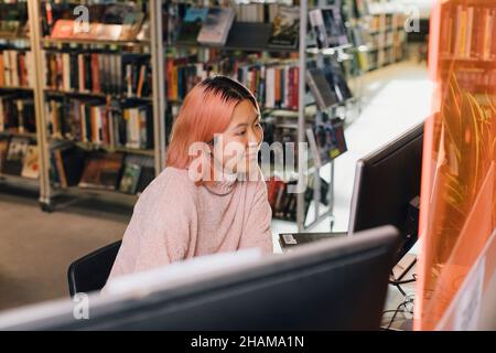 Frau benutzt Computer in der Bibliothek Stockfoto