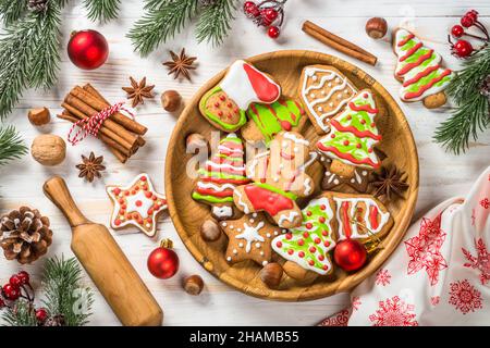 Weihnachts-Lebkuchen auf dem Teller mit Gewürzen und Dekorationen auf weißem Holztisch. Stockfoto