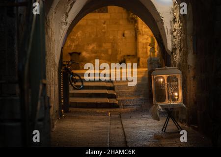 jerusalem-israel. 28-11-2021. Menorah mit brennenden Kerzen am ersten Tag der Chanukka, gelegen in einer alten Straße im jüdischen Viertel der Alten Stadt Stockfoto