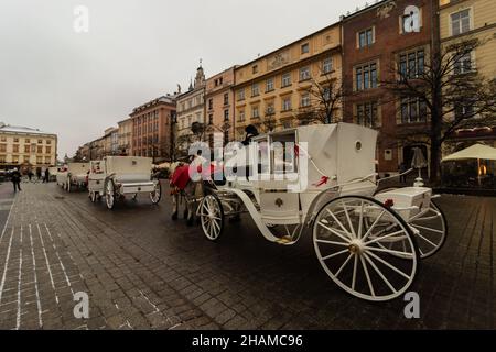 08-12-2021. krakau-polen. Kutschen und Pferde, Touristenattraktion, auf dem Hauptplatz von Krakau in der Altstadt, ein kalter Wintertag Stockfoto