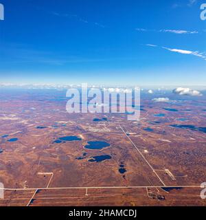 Luftaufnahme der Tundra im Herbst. Oilfield in Sumpfgebiet unter bewölktem Himmel. Umfangreiche GaserzeugProvinz in Westsibirien, Russland. Stockfoto