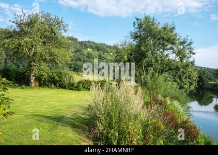 Huntsman Bridge,Huntsman Bridge Camping,Camp,Camping,site,gelegen,neben,River Wye,gelegen im Wye Valley Gebiet von außergewöhnlicher natürlicher Schönheit, befindet sich Huntsham Bridge Camping in einer atemberaubenden Lage am Ufer des Flusses Wye zwischen Goodrich und Symonds Yat. Unser Campingplatz liegt in Reichweite des Forest of Dean und vor der Haustür gibt es viel zu tun, einschließlich Kanufahren, Kajakfahren, Paddle Boarding, Wildschwimmen, Radfahren, Klettern und Wandern (Zugang zum Fluss vom Gelände). Geeignet für Zelte und kleine ‘VW’ große Wohnmobil, da es sich um einen kleinen, freundlichen Campingplatz handelt. Stockfoto