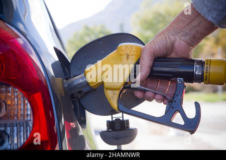 Jemand, der an einer Tankstelle einen Tank mit Benzin befüllt Stockfoto