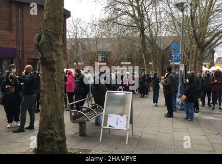 Menschen, die in einem Impfzentrum in Walthamstow, im Osten Londons, nach Auffrischungsjabs Schlange stehen, während das Auffrischungsimpfungsprogramm für Coronaviren auf ein bisher unerreichtes Tempo bei der Entbindung angefahren wird, wobei jedem zugelassenen Erwachsenen in England bis Ende Dezember eine Aufstoppinjektion angeboten wird. Bilddatum: Dienstag, 14. Dezember 2021. Stockfoto