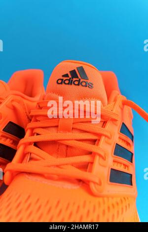 Tjumen, Russland-13. November 2021: Adidas Laufschuhe, orange Korallenfarbe, eq21 Run. Logo Vertikales Foto Stockfoto