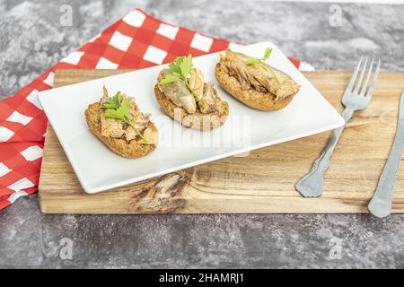 Teller mit geröstetem Brot mit Makrele in eingelegter Sauce, einer typisch spanischen Tapa. Stockfoto
