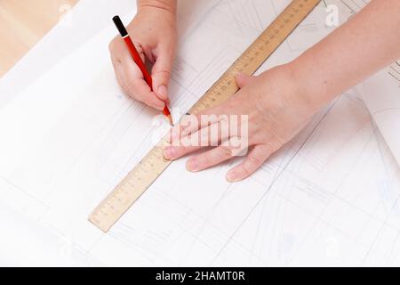 Weibliche Hände machen das Layout des Nähmusters auf Papier Stockfoto