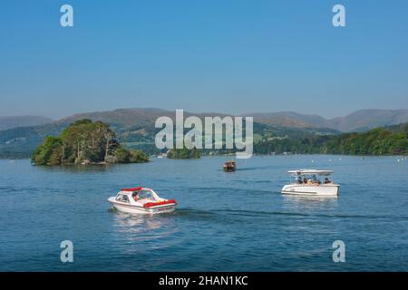 Lake District, Blick im Sommer auf Leute, die kleine Vergnügungsboote auf Lake Windermere, Cumbria, Nordwestengland, Großbritannien, segeln Stockfoto