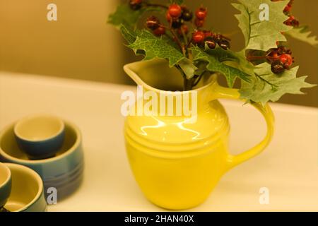 Klassisches Design - Le Creuset Gelber Krug mit Stechbeeren Stockfoto