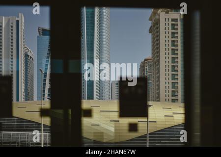 Blick durch das Fenster auf die Dubai Metro Linie mit Wolkenkratzern Hintergrund Stockfoto