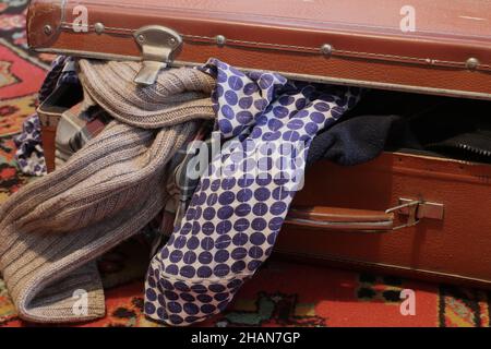 Geschlossener alter Koffer mit Kleidung Stockfoto