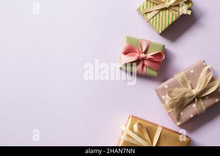 Bunte Geschenkschachteln auf lila Hintergrund. Flach liegend, Draufsicht, Kopierraum Stockfoto