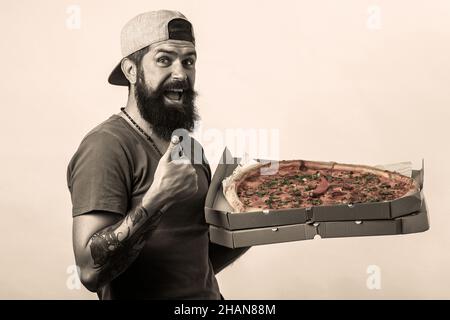 Pizza Delivery Mann mit Arbeit Uniform Abholung Pizza in Box mit Daumen nach oben, weil etwas Gutes passiert ist. Stockfoto