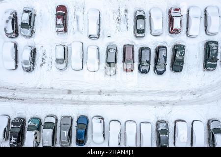 Parkplatz mit Autos, bedeckt von Schnee. Wintersaison. Luftaufnahme von oben. Stockfoto