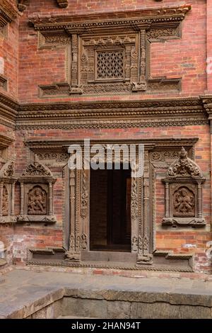 Komplizierte Holzschnitzereien im Sundari Chowk im alten königlichen Palast am Durbar Square, Patan, Nepal. Der Eingang führt zum Mul Chowk. Stockfoto