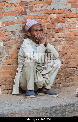 Ein nepalesischer Mann mit dem traditionellen dhaka-Topi-Hut im mittelalterlichen Dorf Newari in Khokana, Nepal. Stockfoto