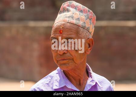 Ein älterer nepalesischer Hindu-Mann mit der traditionellen dhaka-Topi-Mütze und einem tika und Bindi auf der Stirn. Patan, Nepal. Stockfoto