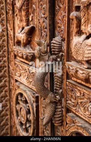 Ein Türgriff aus Gussbronze in Form eines mythischen Makara oder Krokodils im mittelalterlichen Dorf Newar in Khokana, Nepal. Stockfoto