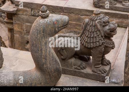 Eine Naga und Löwen bewachen die Tusha Hiti, oder das königliche Bad im Sundari Chowk im alten königlichen Palast auf dem Durbar Square, Patan, Nepal. Stockfoto