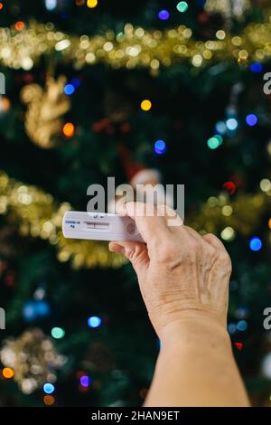 Eine unkenntliche Frau, die sich das covid-Testergebnis für sicheres Reisen während der Weihnachtsferien anschaut Stockfoto