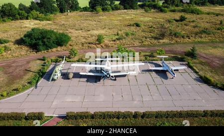 Alte sowjetische Flugzeuge und Hubschrauber auf Ausstellungsfläche im Freilichtmuseum geparkt. Drohnenansicht Foto. Marshal Konev Höhendenkmal in der Nähe von Charkow, Ukraine Stockfoto