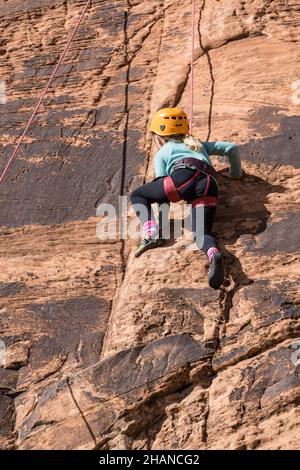 Ein siebenjähriges Mädchen, das im Klettergebiet Wall Street in der Nähe von Moab, Utah, Klettern lernt. Stockfoto