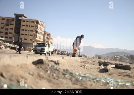 Kabul, Afghanistan. 14th Dez 2021. Ein Mitarbeiter der afghanischen Gemeinde reinigt den Standort einer Explosion in Kabul, der Hauptstadt Afghanistans, am 14. Dezember 2021. Eine Person wurde getötet und zwei andere wurden verletzt, als am Dienstag der Polizeibezirk 8 der Stadt Kabul in Afghanistan durch eine Explosion erschüttert wurde, sagte der stellvertretende Innenminister Mohammad Ezam. Quelle: Saifurahman Safi/Xinhua/Alamy Live News Stockfoto