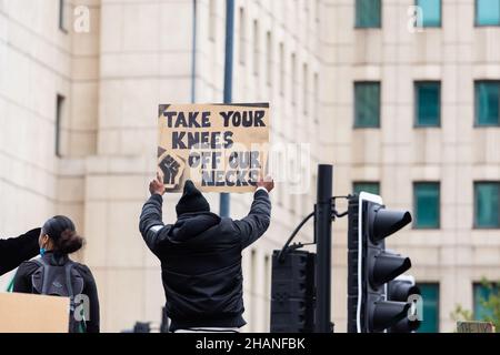 BLM-Protestor mit Schild Nehmen Sie sich das Knie vom Hals London 2020 Stockfoto