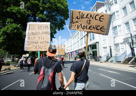 BLM-Demonstranten in Brighton 2020 mit Schweigen ist Gewaltzeichen und ich stehe mit Ihnen Zeichen Stockfoto