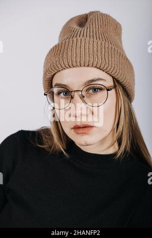 Unverfälscht offen emotionales Porträt einer jungen glücklichen Frau mit blonden langen Haaren auf grauem Hintergrund. Studio-Aufnahme von trendigen lässigen Hipster Mädchen in Stockfoto