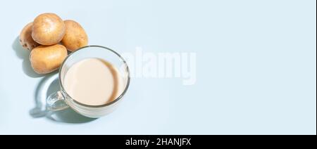 Kartoffelmilch, eine Tasse mit Milch und Kartoffelknollen im Bannerformat. Alternative Pflanzenmilch. Stockfoto