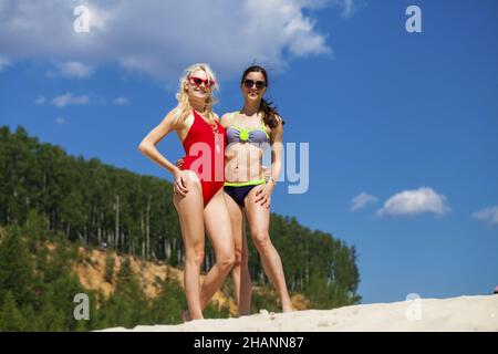 Porträt von zwei jungen Frauen in Badeanzügen posiert auf der Strand Stockfoto