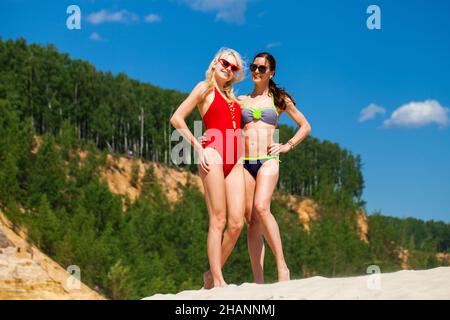 Porträt von zwei jungen Frauen in Badeanzügen posiert auf der Strand Stockfoto