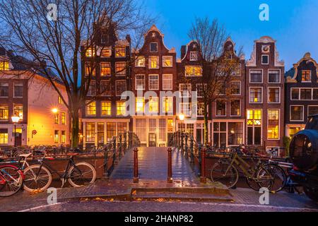 Typische Häuser und Brücke am Amsterdamer Kanal Brouwersgracht bei Nacht, Holland, Niederlande Stockfoto