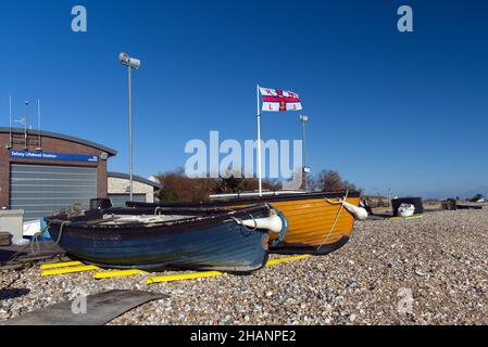Zwei kleine Fischerboote aus Holz am Kiesstrand von Selsey in der Nähe der RNLI Selsey Lifeboat Station. Stockfoto